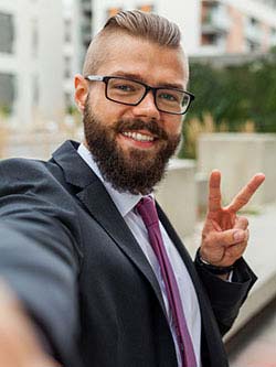 Young man in business attire takes selfie for job application photo